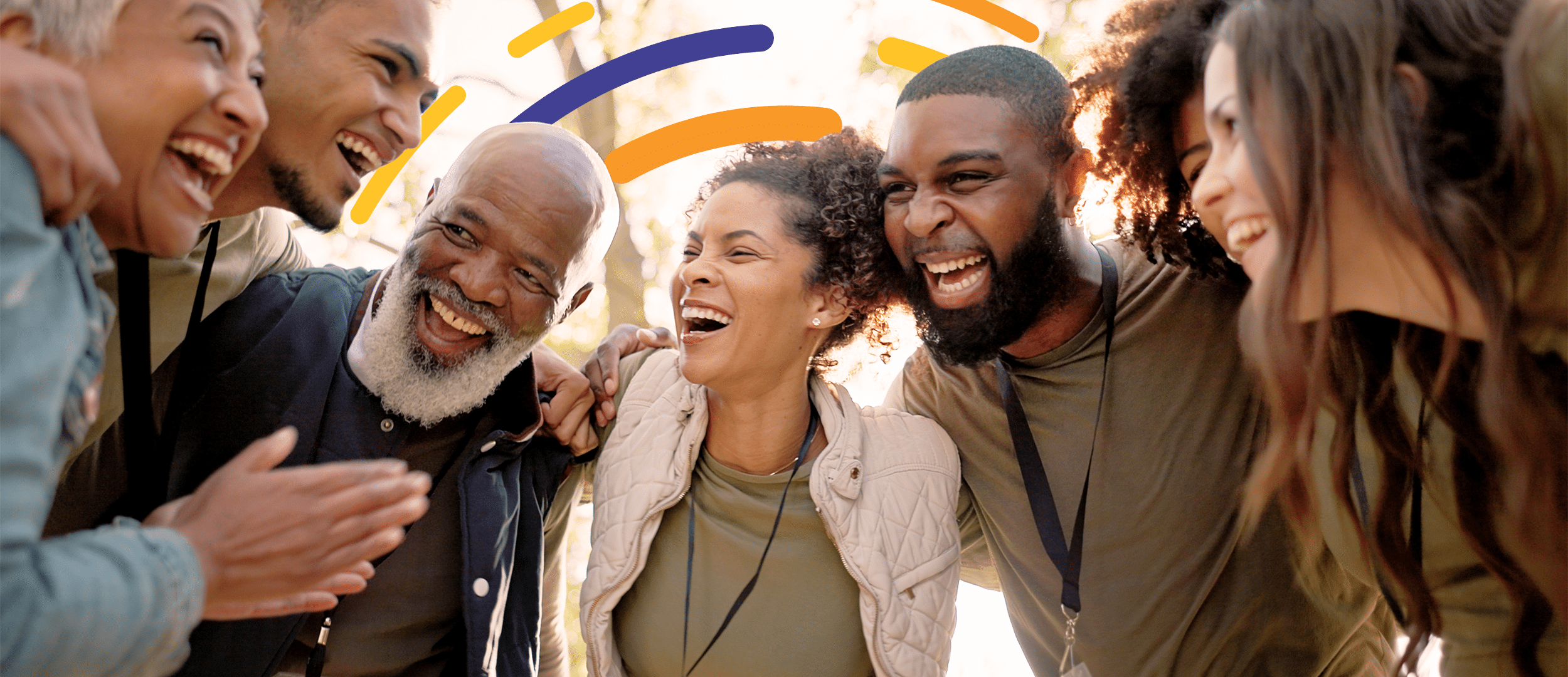 Diverse group of people in a huddle, celebrating together.